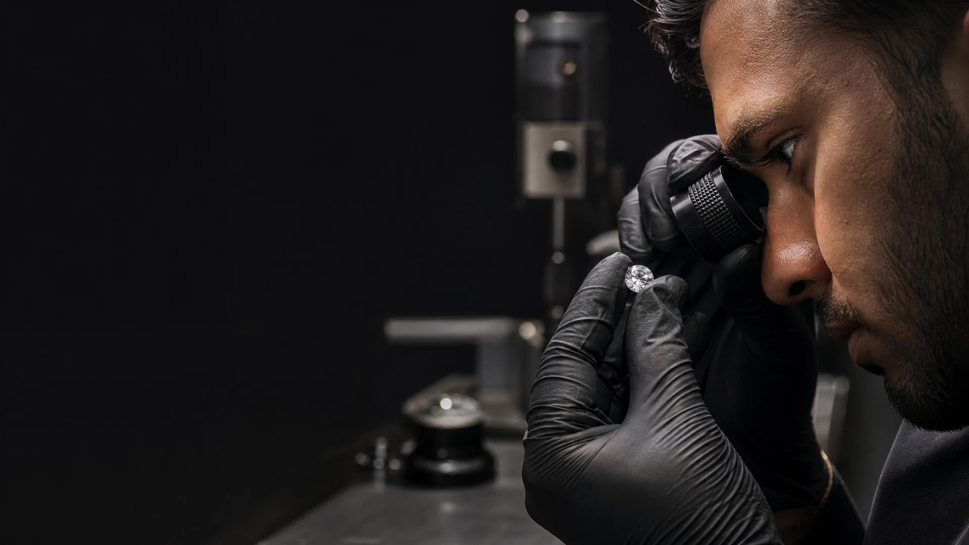Un diamant fini est inspecté à la loupe pendant le contrôle qualité.